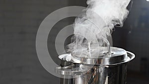 Steam or Vapour clouds rising from boiling water in saucepan on stove. Steam from pan while cooking. Cooking process in