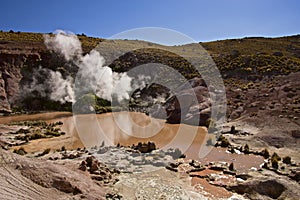 Steam venting from mud pools in Atacama desert photo