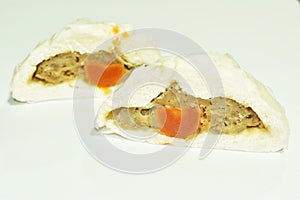 Steamed bao Chinese bun stuffing mashed pork and salt egg half cutting on white background