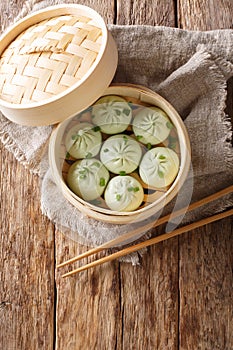 Steamed baozi chinese buns in bamboo steamer closeup. Vertical top view