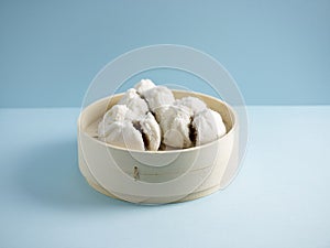 steamed BBQ Honey Pork Bun served in a tray with chopsticks isolated on mat side view on grey marble background