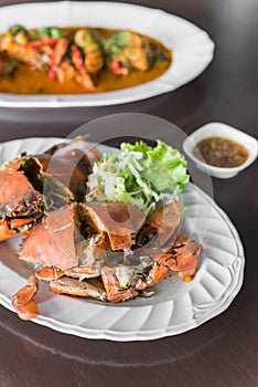 Steamed blue crabs cut in half put on white dish. Selective Focus.