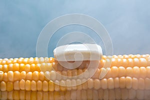 Steamed boiled corn with butter on a blue background.