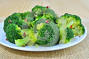 Steamed broccoli with red pepper flakes on plate