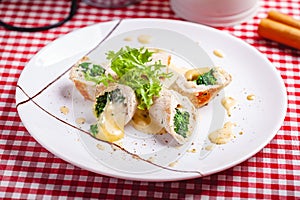 Steamed chicken cutlets stuffed with spinach on white plate