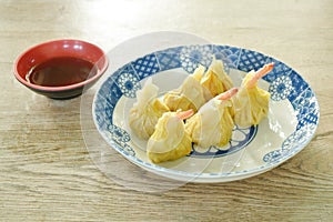 steamed Chinese dumpling filling mashed pork and shrimp or dim sum on plate dipping sour soy sauce