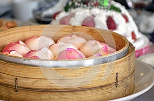 Steamed Chinese Longevity Peach Birthday Buns Served in a Bamboo Steamer