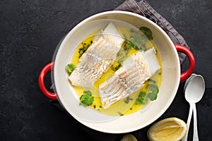 Steamed cod fillet butter-lemon sauce with herbs in the oven. Top view. In a baking dish. Healthy eating,