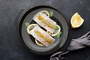 Steamed cod fillet butter-lemon sauce with herbs in the oven. Top view. In a baking dish. Healthy eating,