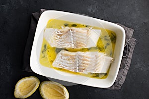 Steamed cod fillet butter-lemon sauce with herbs in the oven. Top view. In a baking dish. Healthy eating,