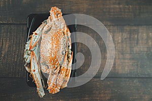 Steamed crab in black plastic container