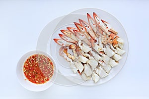 Steamed crab meat in circle plate with spicy chili seafood dipping sauce on white background. Ready to eat. Top view