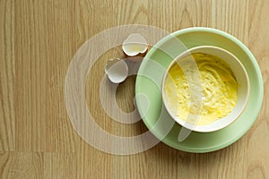 Steamed eggs in a bowl on wooden floor