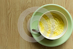 Steamed eggs in a bowl on wooden floor