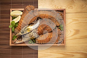 Steamed Flathead lobster with butter and lemon, Boiled Flathead lobster on wooden plate on wooden background