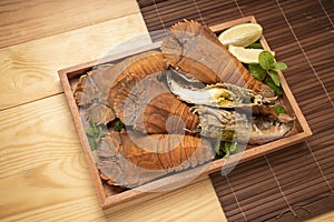 Steamed Flathead lobster with butter and lemon, Boiled Flathead lobster on wooden plate on wooden background