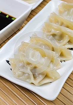 Steamed gyoza dumplings on white plate.