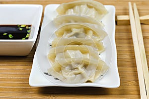 Steamed gyoza dumplings on white plate.