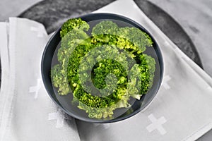 Steamed healthy broccoli vegetables in dark bowl