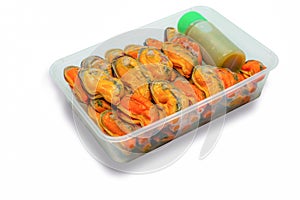 Steamed mussels and delicious bottle of spicy seafood sauce in plastic box for delivery. Cooked mussel meat without shell