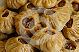 Steamed national Mongolian food dumpling Buuz filled with minced beef, white plate, wooden table, Close up east Siberian Buryats