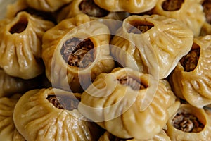 Steamed national Mongolian food dumpling Buuz filled with minced beef, white plate, wooden table, Close up east Siberian Buryats