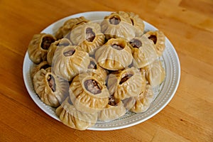 Steamed national Mongolian food dumpling Buuz filled with minced beef, white plate, wooden table, Close up east Siberian Buryats