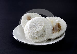 Steamed Rice Cake or Bhapa Pitha is a traditional dish of Bangladesh. Winter rice cake on Black Background. bite or broken pitha.