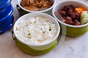 Steamed rice with parsley served in steel food carrier