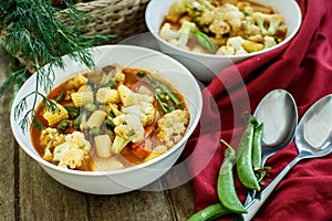 Steamed vegetables in a bowl on wooden table