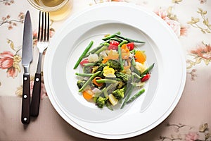 steamed veggie medley on a plate with fork and knife