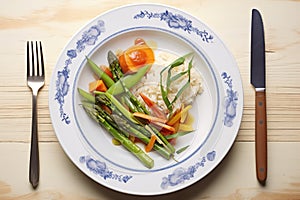 steamed veggie medley on a plate with fork and knife