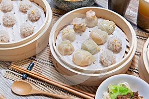 Steamed xiaolongbao and steamed dumplings served in a traditional steaming basket .close up