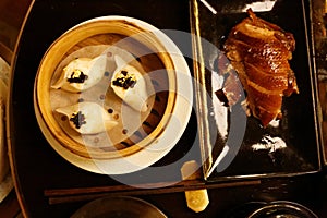 A steamer basket of dim sums and Peking Duck