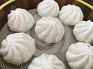 A steamer bun is placed on a wooden board