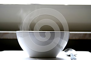 Steaming bowl of soup on table