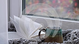 Steaming coffee cup on a rainy day window background. cozy atmosphere, in cold weather. Rainy Day Mood. warming home