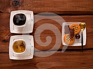 Steaming coffee and tea white cups with sweets on wooden table Hot freshly brewed espresso and herbal mix Breakfast menu