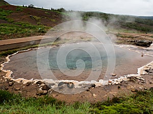 Steaming colorful hot spring pool in Geysir geothermal area