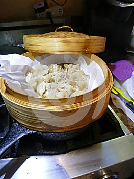 Steaming dim sum shumai in a bamboo basket