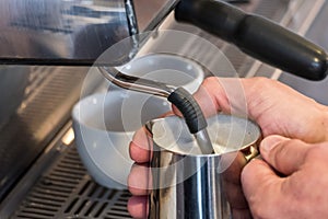 Steaming and frothing milk in tumbler for cappuccino or latte