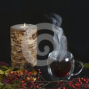 Steaming hot cup of tea with autumn background