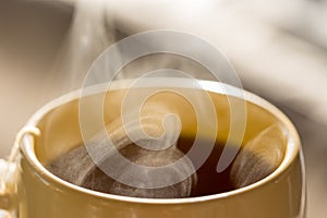 Steaming hot drink in cup close up view