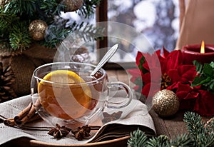 Steaming hot tea with lemmon slice with holiday decorations