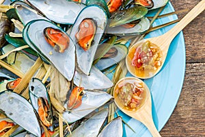 Steaming mussel With delicious sauce on dish with wood table sea