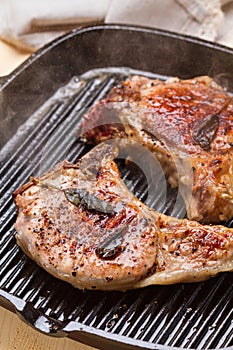 Steaming pork chops on grill frying pan