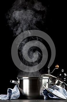 Steaming pot on black background