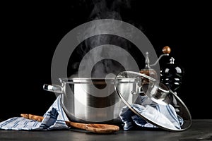 Steaming pot on black background