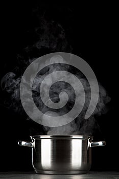 Steaming pot on black background