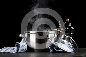 Steaming pot on black background